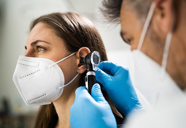 female patient's ear examined by doctor